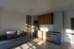 Modern small room with kitchen area and wooden floor photo