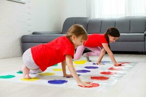 two little girls Having Fun Playing Game On Floor At Home. Siblings Friendship photo