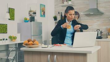 Business Woman late at the office while eating breakfast. Young freelancer working around the clock to meet her goals, stressful way of life, hurry, late for work, always on the run photo