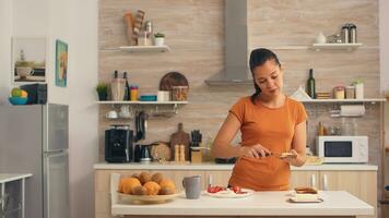 Woman spreading butter on toasted bread for breakfast. Knife smearing soft butter on slice of bread. Healthy lifestyle, making morning delicious meal in cozy kitchen. Traditional tasty lunch photo