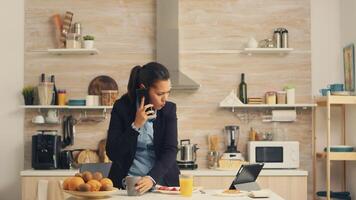 Freelancer late at work while eating breakfast in a hurry. Concentrated business woman in the morning multitasking in the kitchen before going to the office, stressful way of life, career and goals to meet photo