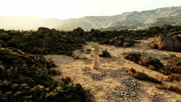 un devanado suciedad la carretera en el escénico montaña paisaje con un cementerio cruzar video