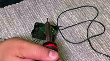 Close-up of a man's hands. A man solders an electric board. Revision of the New Year's garland on Christmas Eve. video