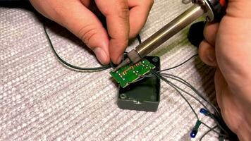 Close-up of a man's hands. A man solders an electric board. Revision of the New Year's garland on Christmas Eve. video