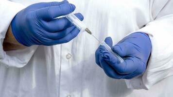 Hands in blue latex gloves close-up. Syringe in women's hands. photo