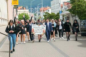 Nitra, Slovakia - 05.19.2023 Beautiful school graduates have fun and rejoice and walk along the city streets. photo