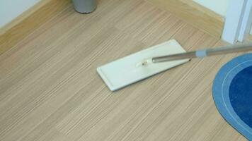 uma esfregão este é limpeza a artificial madeira chão. video