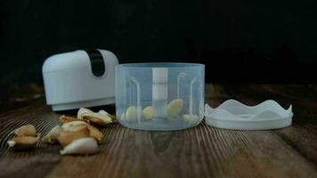 Fallen garlic cloves into the bowl of a garlic blender. video