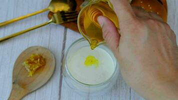 Breakfast set Male hand pouring honey into a glass of milk with bread video