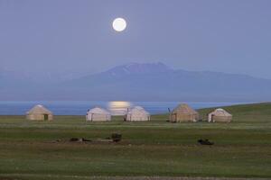 Moon rising over Song Kol lake and nomads Yurts, Naryn province, Kyrgyzstan, Central Asia photo