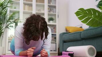 een toegewijd vrouw saldi in een yoga houding, haar mat gelegd uit in de sereen ruimte van haar huis video