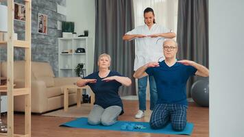 Senior couple doing physical therapy with doctor at home. Home assistance, physiotherapy, healthy lifestyle for old person, training and healthy lifestyle photo