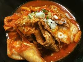 Korean food Kimchi soup in a black plate. photo
