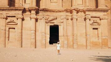 caucasian kvinna turist promenad förbi utforska ad deir eller el deir, de monument ristade ut av sten i de gammal stad petra, jordan. unesco värld arv webbplats video