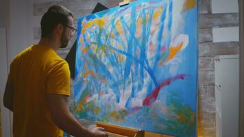 Artist paints on large canvas with fingertips in art studio. photo