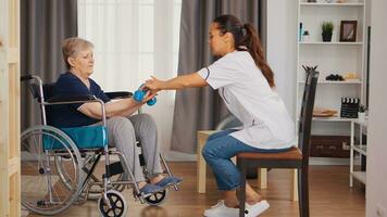 Nurse helping senior woman in wheelchair with rehabilitation. Training, sport, recovery and lifting, old person retirement home, healthcare nursing, health support, social assistance, doctor and home service photo