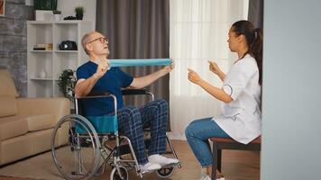 discapacitado mayor paciente en silla de ruedas durante rehabilitación con terapeuta. discapacitado minusválido antiguo persona con social trabajador en recuperación apoyo terapia fisioterapia cuidado de la salud sistema enfermería Jubilación hogar foto