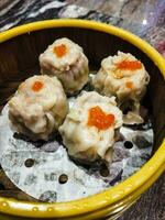 steamed dumplings with red fish egg in bamboo steamer photo