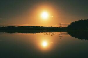 Sunset on a lake in Sweden. The moonlight is reflected in the calm water.Scandinavia photo