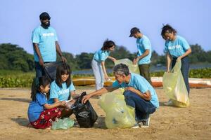 equipo de joven y diversidad voluntario trabajador grupo disfrutar Caritativo social trabajo al aire libre en limpieza arriba basura y residuos separación proyecto a río playa foto