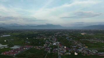 aerial view of settlements in the countryside with mountains in the background video