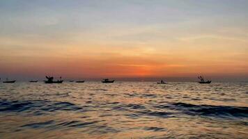 fishing boats during sunset sky at beach landscape, fishing boats during a sunrise or sunset, shimmering of the sun on the clouds,the sky and clouds have the power to inspire feelings of awe or wonder video