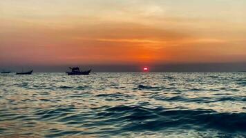 fishing boats during sunset sky at beach landscape, fishing boats during a sunrise or sunset, shimmering of the sun on the clouds,the sky and clouds have the power to inspire feelings of awe or wonder video