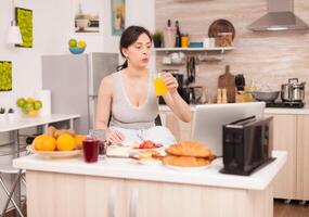 Woman making online shopping in the morning during breakfast paying with credit card. Entering information, customer using ecommerce technology buying stuff on the web, cosumerism banking and ordering photo