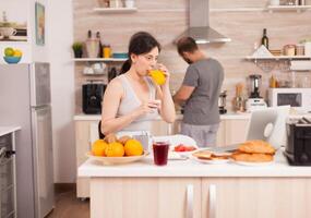 Pretty woman shopping online via interet during breakfast with husband, paying with credit card. Entering information, customer using ecommerce technology buying stuff on the web, cosumerism banking and ordering photo