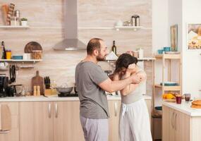 Married couple arguing at the kitchen during breakfast. Domestic violence threatening aggressive angry frustrated husband abusing physical depressed sad unhappy crying stressed woman. Home abuse photo