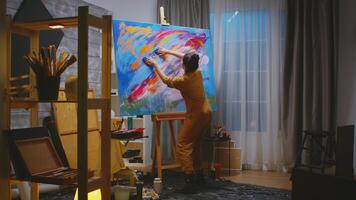 Painter using fingers on large canvas making a masterpiece in art studio. photo