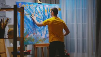 Impressionism painter in art studio painting with fingers on large canvas. photo