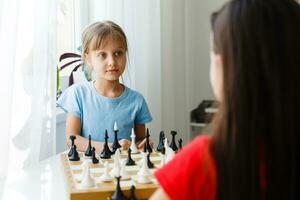 Two cute children playing chess at home photo