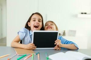 Pretty stylish schoolgirls studying during her online lesson at home, social distance during quarantine, self-isolation, online education concept photo