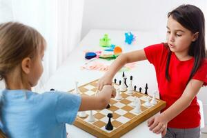 Two cute children playing chess at home photo