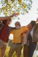 friends of different ages hugging together in nature against the backdrop of sunset celebrating a good walk together photo