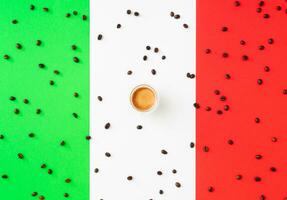 Creative layout made of cup of coffee and coffee beans on flag of Italy as a background. Minimal coffee concept. Trendy espresso idea. Unique flat lay composition. Coffee aesthetic. photo