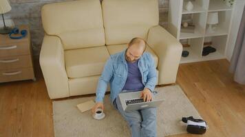 Top view of caucasian man working on laptop and enjoying a cup of coffee photo