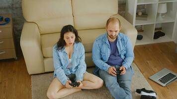 Young couple playing video games with wireless controllers. photo