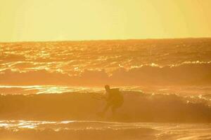 un hombre kiteboarding en el Oceano a puesta de sol foto