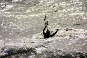 a man kiteboarding in the ocean at sunset photo