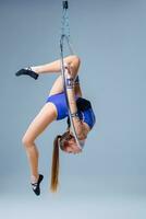 linda artístico gimnasta hacer ejercicio con colgando aro foto