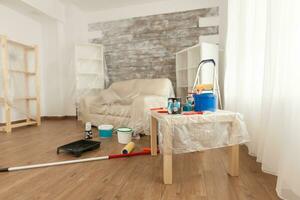 Tools ready for renovation placed on the floor of the room. Home during renovation, decoration and painting. Interior apartment improvement maintenance. Roller, ladder for house repair photo