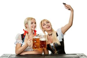 Young women in traditional Bavarian clothes, dirndl or tracht, on white background. photo