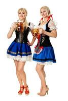 Full length portrait of a two blond womans with traditional costume holding beer glasses isolated on white background. photo