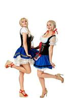 A full length portrait of two beautiful women in a traditional costume isolated on white. Oktoberfest photo