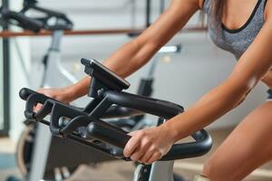 mujer manos en un bar estacionario bicicleta el gimnasio foto