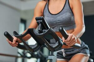 Stationary bicycles fitness girl in a gym sport club. photo