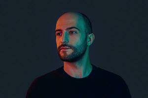 Portrait of a handsome bearded young man in a black sweater looking away. photo