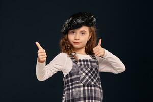 Stylish brunette kid is posing in studio on a black background. Children's fashion. photo